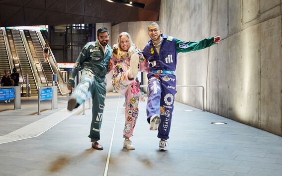 Kolme haalariasuista opiskelijaa metroasemalla