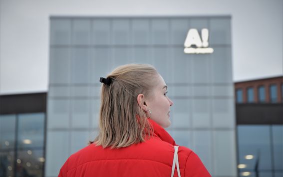 Nouri nainen Aalto-yliopiston rakennuksen edessä